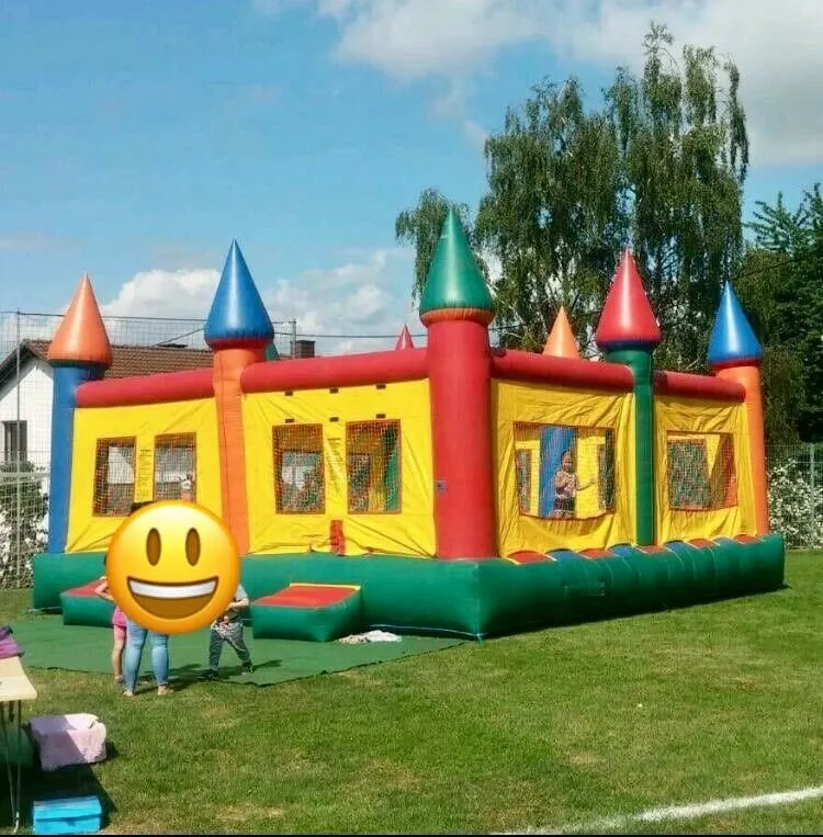 Bunte XXL Hüpfburg mit Türmen und spielenden Kindern